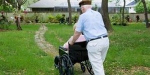 Persona in carrozzina spinta da un uomo anziano