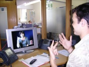 Uomo sordo parla al computer con una donna, tramite la Lingua dei Segni