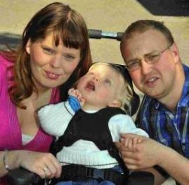 Madre e padre con la loro bimba disabile