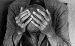 Foto in bianco e nero di uomo con le mani sulla testa