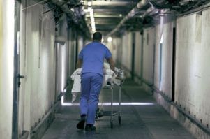 Infermiere spinge una lettiga in un corridoio di ospedale