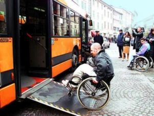Uomo in carrozzina sale in un autobus grazie a una rampa