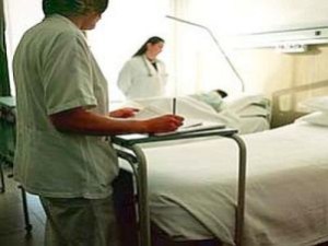 Infermiera e medico a fianco di un letto di ospedale