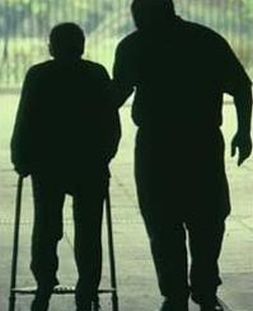 Ombra di persona con malattia di Parkinson, assistita da un'altra persona