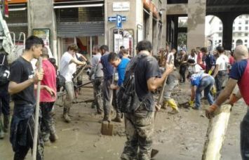 Volontari ripuliscono dal fango le strade di Genova