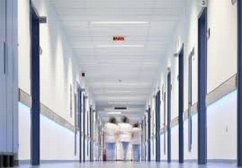 Immagine sfuocata di operatori sanitari in fondo a un corridoio di ospedale