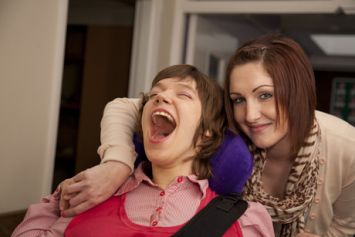 Giovane donna con disabilità insieme a un'assistente