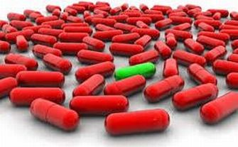 Capsula di farmaco verde tra tante capsule rosse