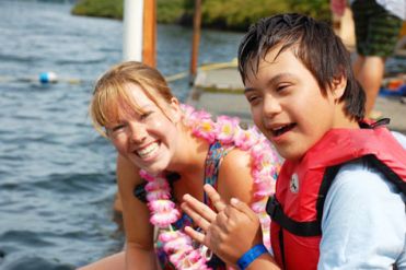 Giovane con disabilità intellettiva al mare, insieme a una ragazza non disabile