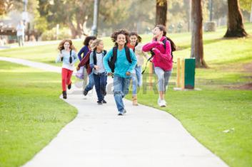 Gruppo di bambini che corrono sul viale di un parco