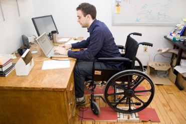 Giovane con disabilità in carrozzina al computer