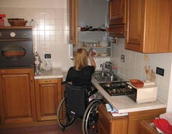 Persona con disabilità in carrozzina in una cucina accessibile