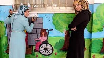 Giovani donne palestinesi realizzano un murale