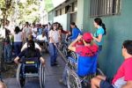 Ragazzi e ragazze con varie disabilità davanti a una scuola