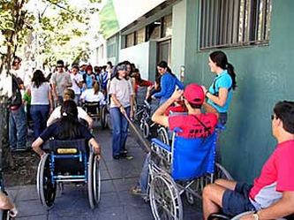 Ragazzi e ragazze con varie disabilità davanti a una scuola