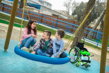 Bambini con e senza disabilità in un parco giochi accessibile