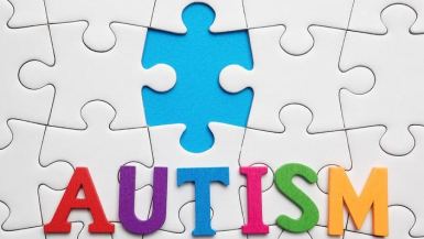 Puzzle con la parola "Autism" in lettere colorate e un pezzo mancante blu