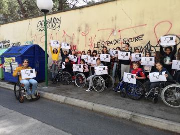 Claudio Ferrante e i ragazzi della Scuola Media Antonelli di Pescara con cartelli che riportano un pollice verso