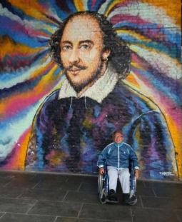 Persona di Concrete ONLUS a Londra, davanti a un murale di Shakespeare