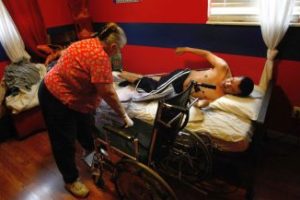 Una caregiver familiare assiste una persona con disabilità grave
