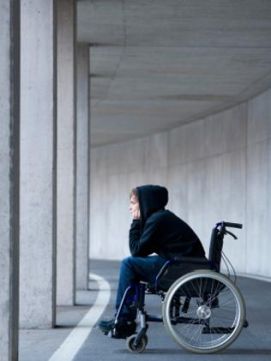 Persona con disabilità in carrozzina con il cappuccio
