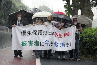 Uomo vittima di sterilizzazione forzata in Giappone manifesta con i suoi avvocati (©Ansa)