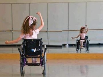 Bambina con disabilità danza davanti a uno specchio