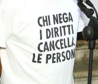Persona con maglietta e la scritta "Chi nega i diritti cancella le persone"