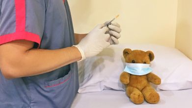 Vacciino somministrato a un orsacchiotto di peluche con mascherina