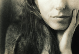 Parte inferiore del volto di una donna, con espressione pensierosa. Foto in bianco e nero