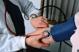 Medico che misura la pressione sanguigna ad un paziente