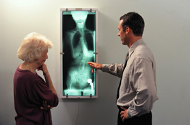 un medico mostra la radiografia scheletrica a un paziente