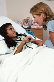 Dottoressa assiste piccola paziente in un letto di ospedale