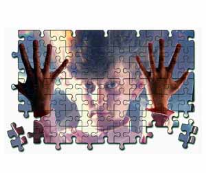 Bimbo dietro a un puzzle: immagine che simboleggia l'autismo