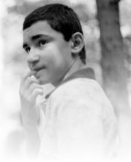 Ragazzo fotografato in bianco e nero di profilo, con dito in bocca