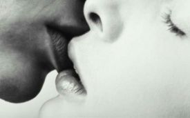 Foto in bianco e nero di un bacio tra una donna e un uomo