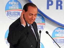 Silvio Berlusconi con la mano destra vicina all'orecchio