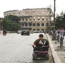 Persona con disabilità di fronte al Colosseo a Roma