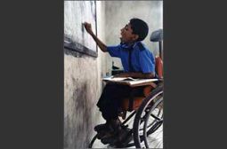 Ragazzo con disabilità scrive su una lavagna