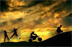 Crinale di una montagna sullo sfondo d un cielo nuvoloso, con una persona in carrozzina che sale davanti a una moto