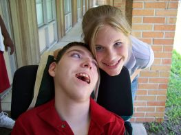 Persona con grave disabilità insieme a giovane donna non disabile