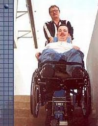 Persona con disabiltà su una scala, con l'accompagnatore