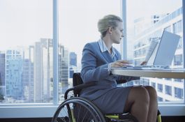 Donna con disabilità al lavoro davanti a un computer