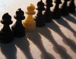 Molte pedine di scacchi nere, tra le quali una bianca: rappresenta la discriminazione
