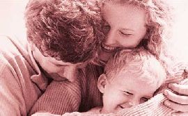 Foto seppiata con genitori e un bimbo tutti abbracciati