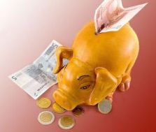 Introduzione di soldi in salvadanaio a forma di porcellino