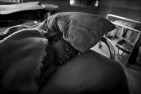 Donna nigeriana con problemi psichici stesa in un letto