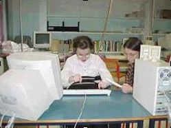 Ragazza con disabilità davanti al computer insieme a insegnante di sostegno