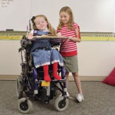 Bimba in carrozzina insieme a compagna di scuola non disabile