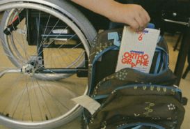 Particolare di alunno con disabilità che ripone libro nello zainetto